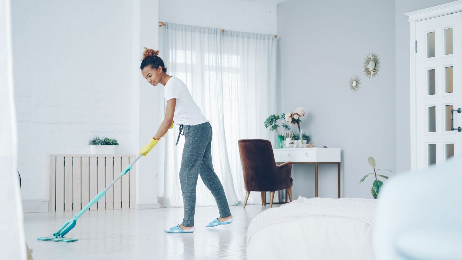 A professional cleaner mopping a bright, modern home